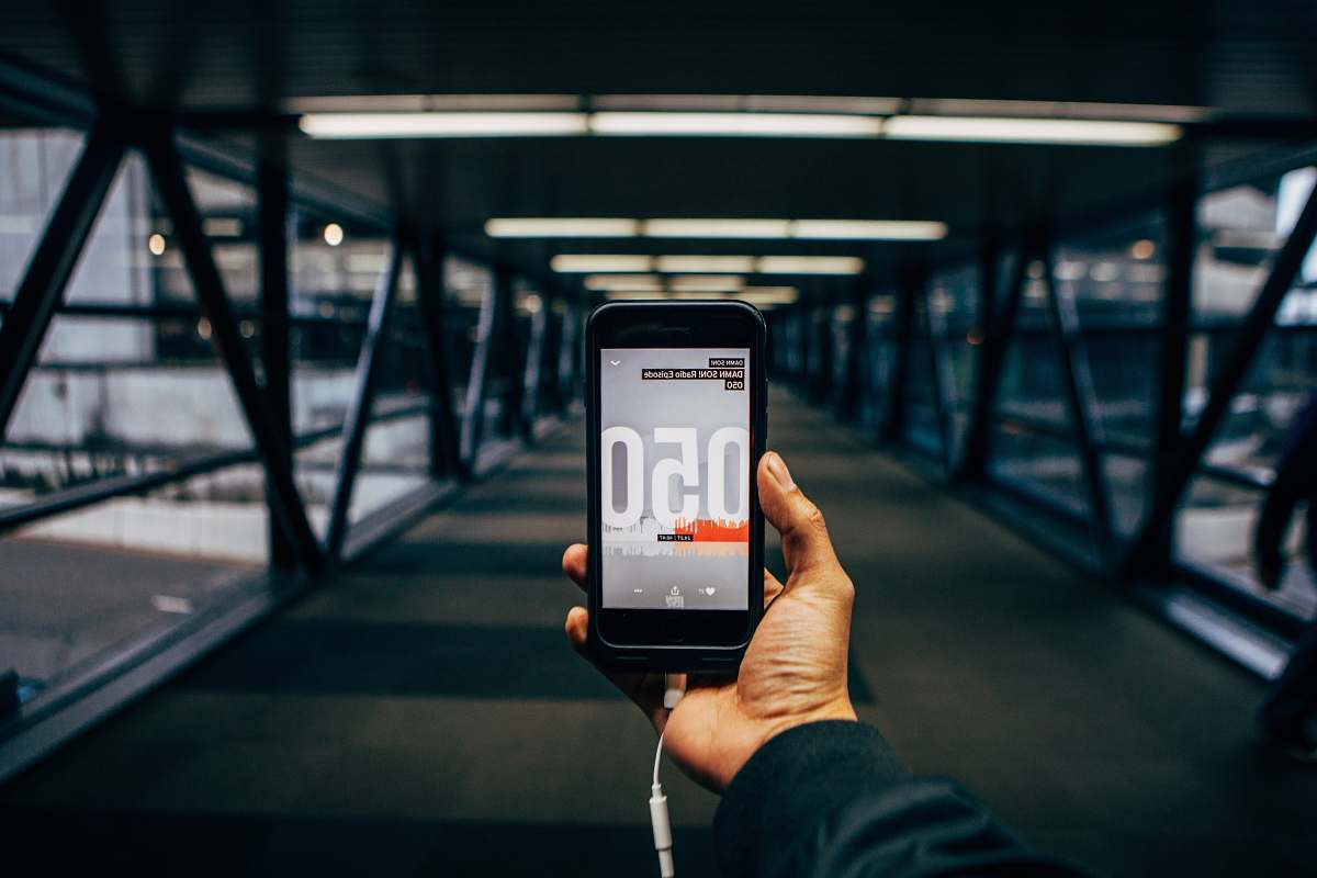 mobile phone person holding black smartphone while standing on bridge electronics